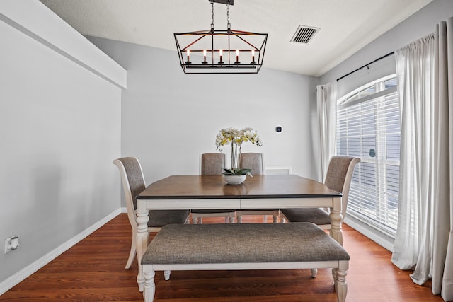 421 NW Cornell Ave, Port Saint Lucie, FL 34983 - dining space with healthy amount of natural light, a chandelier, wood finished floors, and vaulted ceiling