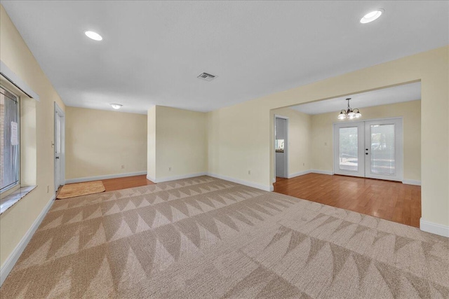 11061 NW 45th St, Coral Springs, FL 33065 - spare room with carpet floors, a chandelier, french doors, recessed lighting, and wood finished floors