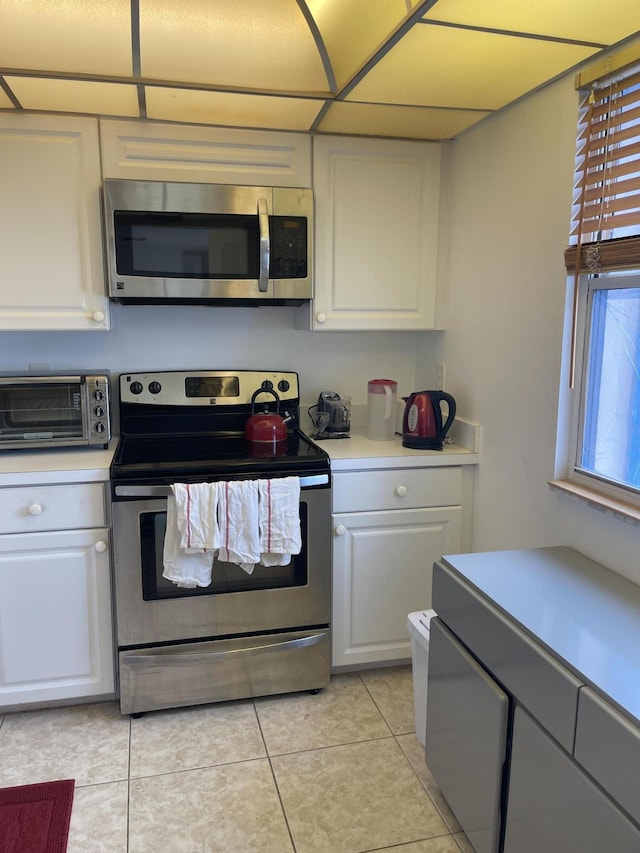5200 N Flagler Dr Unit 1106, West Palm Beach, FL 33407 - kitchen featuring appliances with stainless steel finishes, light countertops, white cabinetry, and light tile patterned floors