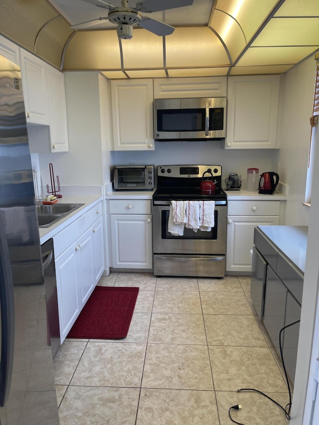 5200 N Flagler Dr Unit 1106, West Palm Beach, FL 33407 - kitchen with appliances with stainless steel finishes, light countertops, white cabinetry, a ceiling fan, and light tile patterned floors