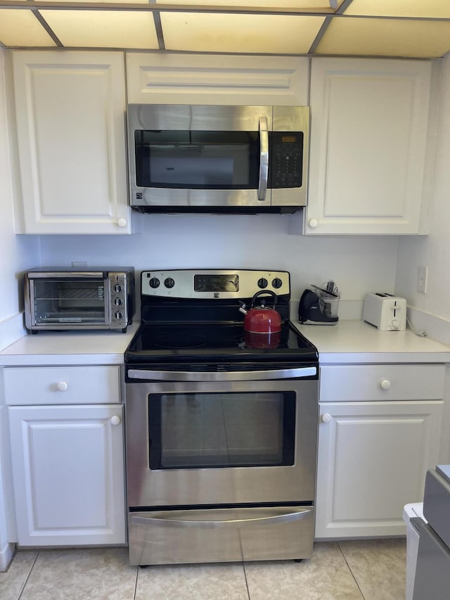 5200 N Flagler Dr Unit 1106, West Palm Beach, FL 33407 - kitchen featuring appliances with stainless steel finishes, white cabinets, light countertops, and light tile patterned floors
