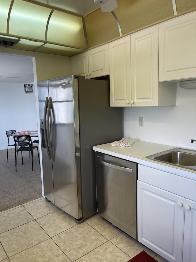 5200 N Flagler Dr Unit 1106, West Palm Beach, FL 33407 - kitchen with appliances with stainless steel finishes, white cabinets, light countertops, and light carpet