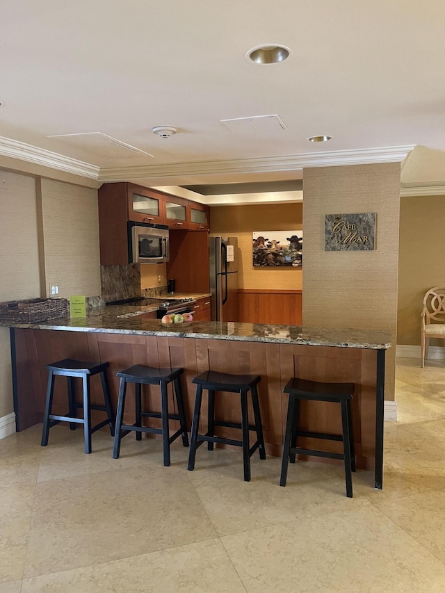 5200 N Flagler Dr Unit 1106, West Palm Beach, FL 33407 - bar area featuring stainless steel appliances, ornamental molding, and backsplash