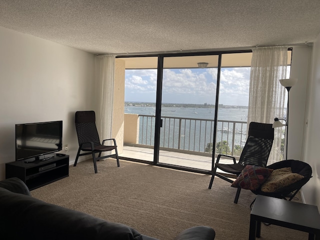 5200 N Flagler Dr Unit 1106, West Palm Beach, FL 33407 - carpeted living room featuring a wall of windows, a water view, and a textured ceiling