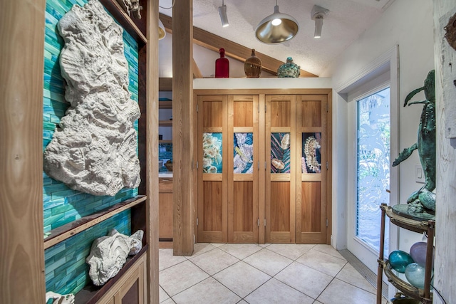 116 Dunes Edge Rd, Jupiter, FL 33477 - foyer featuring lofted ceiling, light tile patterned floors, and a textured ceiling