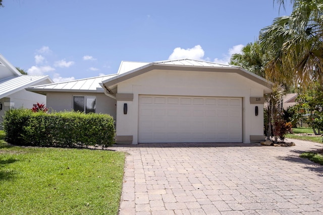 116 Dunes Edge Rd, Jupiter, FL 33477 - ranch-style home with a standing seam roof, stucco siding, a front lawn, a metal roof, and an attached garage