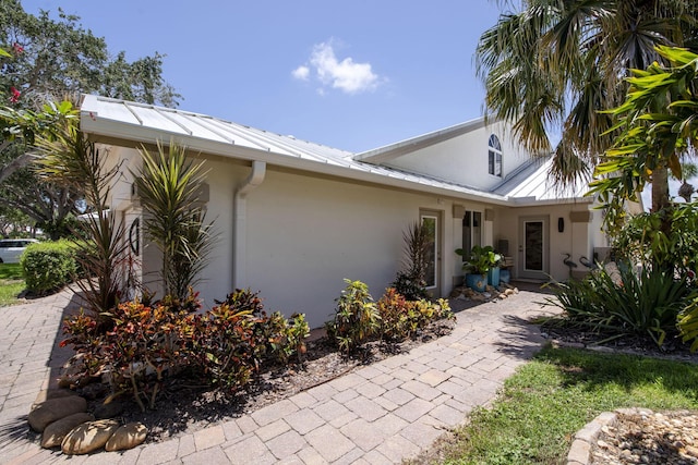 116 Dunes Edge Rd, Jupiter, FL 33477 - view of front facade featuring stucco siding and a metal roof