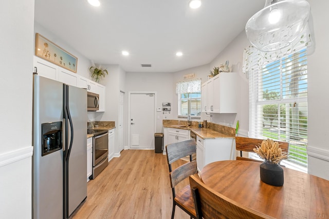 876 SW Rocky Bayou Ter, Port Saint Lucie, FL 34986 - kitchen with appliances with stainless steel finishes, white cabinetry, recessed lighting, light wood-style flooring, and light stone countertops