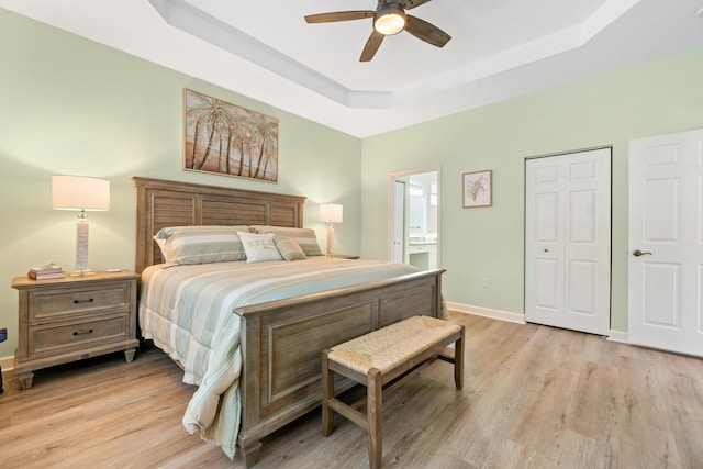 876 SW Rocky Bayou Ter, Port Saint Lucie, FL 34986 - bedroom with a tray ceiling, light wood finished floors, ensuite bath, and ceiling fan