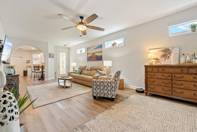 876 SW Rocky Bayou Ter, Port Saint Lucie, FL 34986 - living room with arched walkways, healthy amount of natural light, ceiling fan, and light wood-style floors