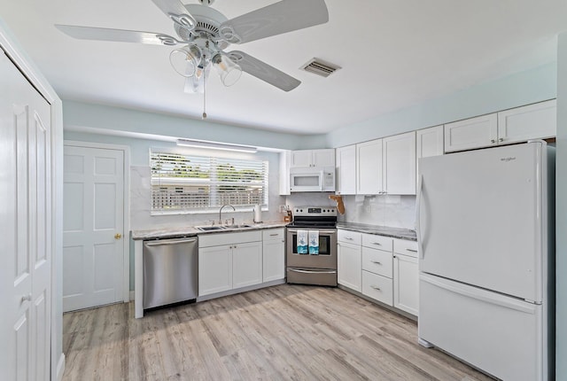 1157 NW 14th Ter, Stuart, FL 34994 - kitchen with appliances with stainless steel finishes, white cabinetry, ceiling fan, light wood-style floors, and light countertops