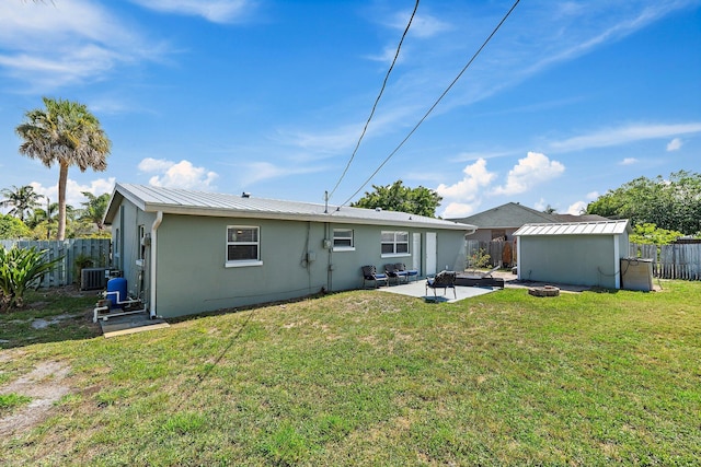 1157 NW 14th Ter, Stuart, FL 34994 - rear view of property featuring a fenced backyard, a patio area, a fire pit, an outdoor structure, and stucco siding