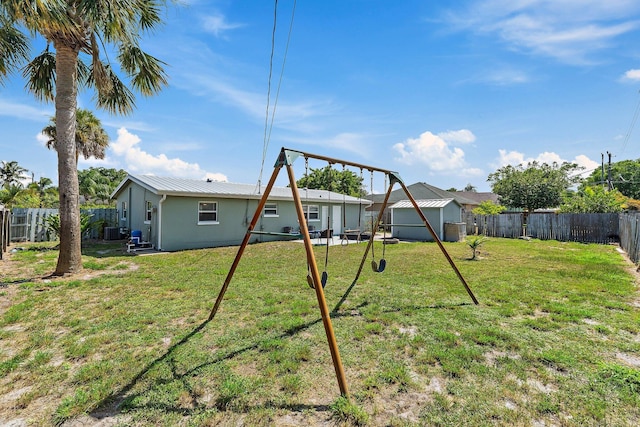 1157 NW 14th Ter, Stuart, FL 34994 - back of house featuring a fenced backyard, a metal roof, and a shed