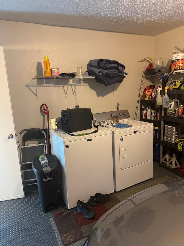 327 NE Surfside Ave, Port Saint Lucie, FL 34983 - laundry area with washing machine and dryer, dark colored carpet, and a textured ceiling
