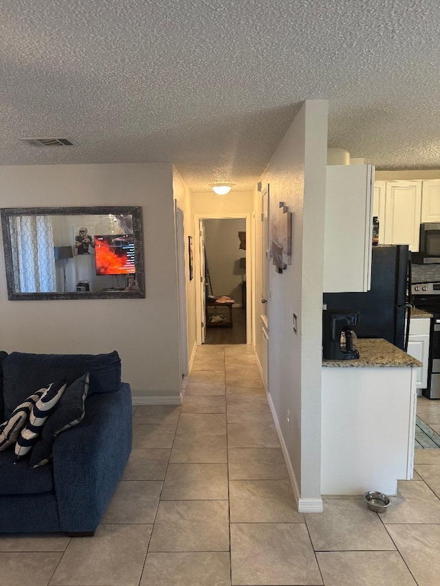 327 NE Surfside Ave, Port Saint Lucie, FL 34983 - corridor with a textured ceiling and light tile patterned floors