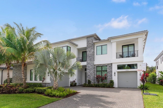 17432 Ponte Chiasso Dr, Boca Raton, FL 33496 - modern home with stucco siding, stone siding, decorative driveway, a balcony, and a front yard