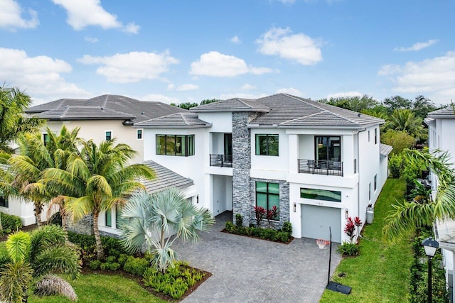 17432 Ponte Chiasso Dr, Boca Raton, FL 33496 - view of front of house with a balcony, stucco siding, stone siding, and decorative driveway