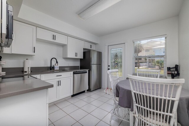 346 Hernando St, Hutchinson Island, FL 34949 - kitchen with stainless steel appliances, white cabinets, dark countertops, and light tile patterned floors