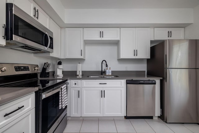 346 Hernando St, Hutchinson Island, FL 34949 - kitchen featuring appliances with stainless steel finishes, light tile patterned flooring, white cabinets, and dark countertops