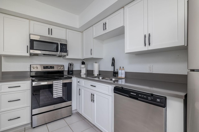 346 Hernando St, Hutchinson Island, FL 34949 - kitchen with stainless steel appliances, white cabinetry, light tile patterned flooring, and dark countertops