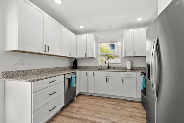 346 Hernando St, Hutchinson Island, FL 34949 - kitchen featuring appliances with stainless steel finishes, white cabinets, recessed lighting, light stone countertops, and light wood-style flooring