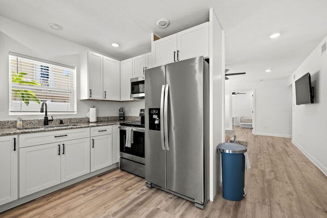 346 Hernando St, Hutchinson Island, FL 34949 - kitchen with appliances with stainless steel finishes, light wood finished floors, stone countertops, white cabinetry, and ceiling fan