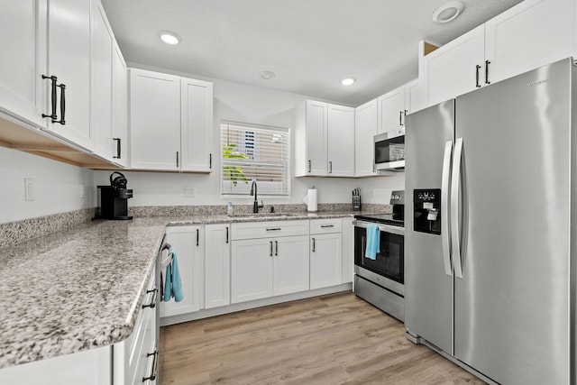 346 Hernando St, Hutchinson Island, FL 34949 - kitchen featuring stainless steel appliances, white cabinets, recessed lighting, and light stone counters