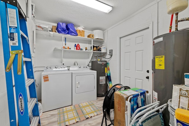 346 Hernando St, Hutchinson Island, FL 34949 - laundry room featuring washer and dryer, water heater, a textured ceiling, and light wood-style floors