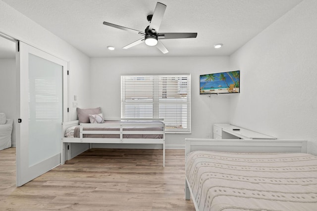 346 Hernando St, Hutchinson Island, FL 34949 - bedroom featuring a textured ceiling, light wood-style floors, a ceiling fan, and recessed lighting