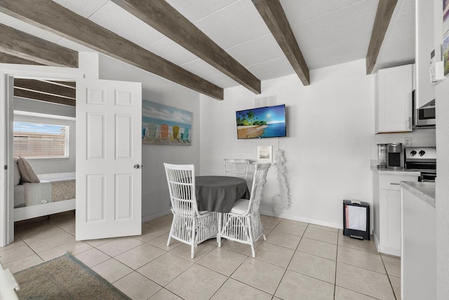 346 Hernando St, Hutchinson Island, FL 34949 - dining area with beamed ceiling and light tile patterned flooring
