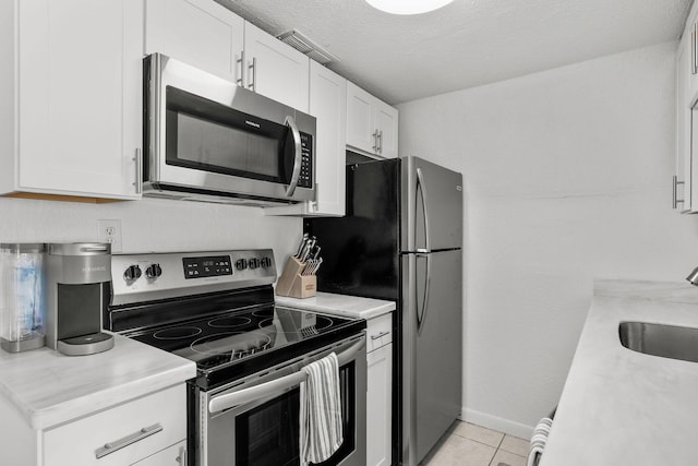 346 Hernando St, Hutchinson Island, FL 34949 - kitchen with appliances with stainless steel finishes, light countertops, white cabinetry, and light tile patterned floors