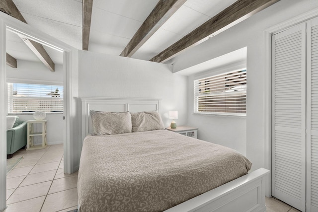 346 Hernando St, Hutchinson Island, FL 34949 - bedroom with beamed ceiling, light tile patterned floors, multiple windows, and a closet