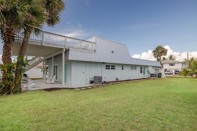 346 Hernando St, Hutchinson Island, FL 34949 - back of house featuring a yard, a patio area, a metal roof, and a deck