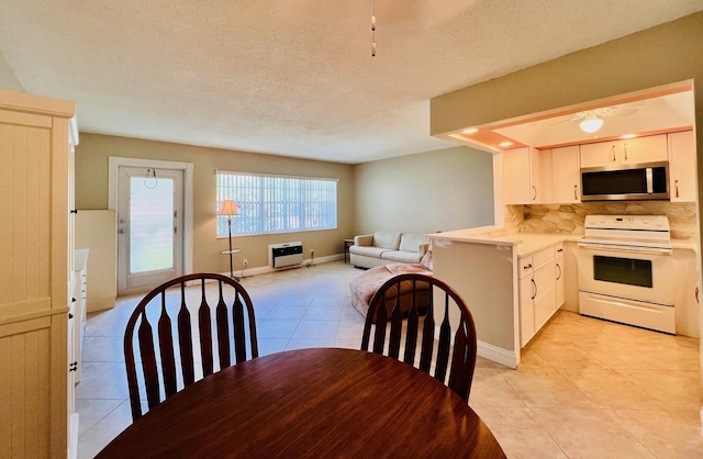 304 Sheffield M, West Palm Beach, FL 33417 - kitchen featuring white appliances, light tile patterned floors, backsplash, light countertops, and a textured ceiling