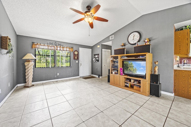 1882 SW Agnes St, Port Saint Lucie, FL 34953 - unfurnished living room with vaulted ceiling, ceiling fan, light tile patterned floors, and a textured ceiling