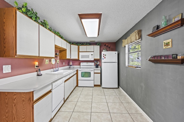 1882 SW Agnes St, Port Saint Lucie, FL 34953 - kitchen with white appliances, a textured ceiling, light countertops, white cabinets, and light tile patterned flooring