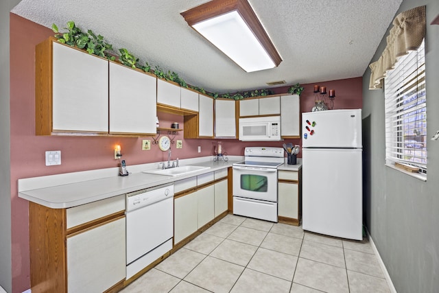 1882 SW Agnes St, Port Saint Lucie, FL 34953 - kitchen with white appliances, a textured ceiling, light countertops, light tile patterned floors, and white cabinets