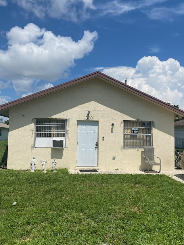 1310 W 24th St, Riviera Beach, FL 33404 - view of front facade with a front yard and stucco siding