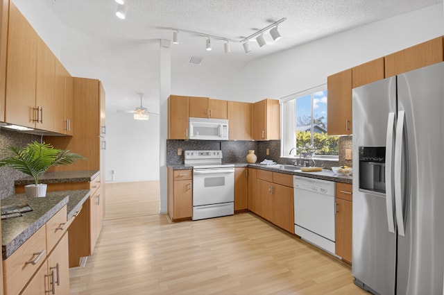 2915 NW 14th St, Delray Beach, FL 33445 - kitchen featuring white appliances, dark countertops, light wood-style floors, and vaulted ceiling