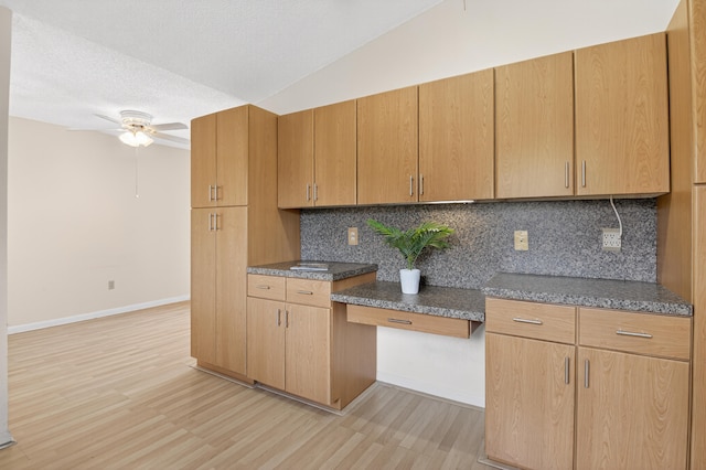 2915 NW 14th St, Delray Beach, FL 33445 - kitchen with light wood finished floors, decorative backsplash, ceiling fan, dark countertops, and vaulted ceiling