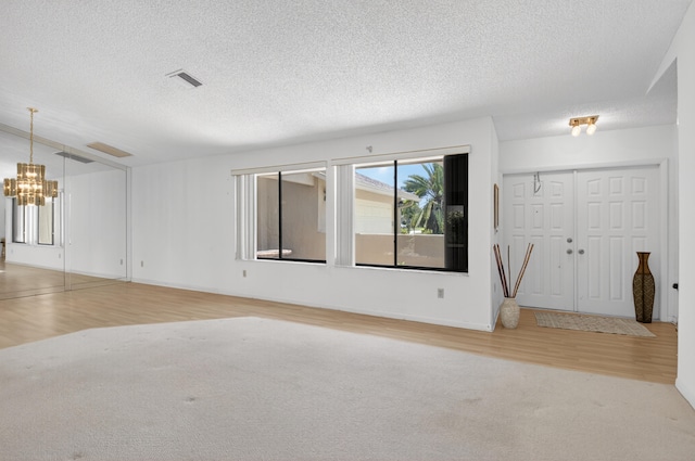 2915 NW 14th St, Delray Beach, FL 33445 - unfurnished room with wood finished floors, a chandelier, and a textured ceiling