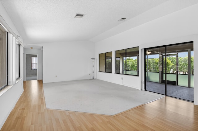 2915 NW 14th St, Delray Beach, FL 33445 - spare room with wood finished floors, a textured ceiling, and vaulted ceiling