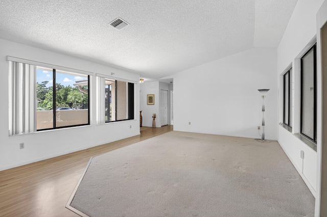 2915 NW 14th St, Delray Beach, FL 33445 - empty room with a textured ceiling, light wood-style flooring, and lofted ceiling