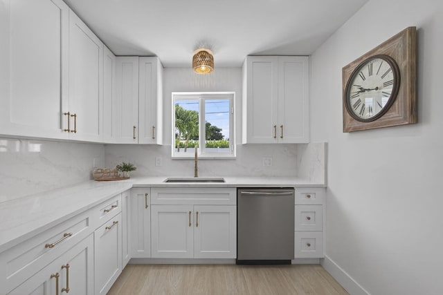 131 Cruiser Rd S, North Palm Beach, FL 33408 - kitchen with dishwasher, white cabinets, backsplash, light wood-type flooring, and light stone counters