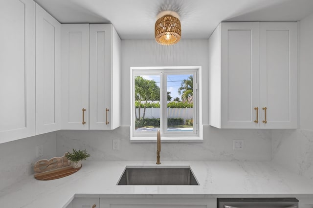 131 Cruiser Rd S, North Palm Beach, FL 33408 - kitchen with white cabinets, a chandelier, light stone counters, decorative backsplash, and dishwasher