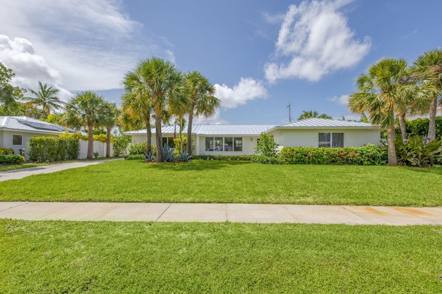 131 Cruiser Rd S, North Palm Beach, FL 33408 - ranch-style home with a front lawn, a metal roof, and stucco siding