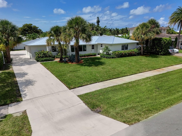 131 Cruiser Rd S, North Palm Beach, FL 33408 - ranch-style home with driveway, a front yard, a metal roof, and stucco siding