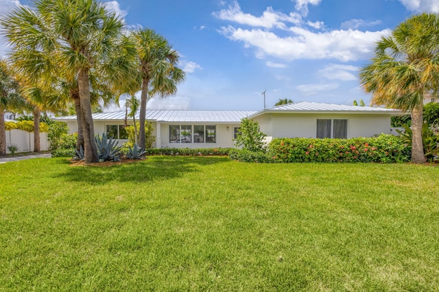 131 Cruiser Rd S, North Palm Beach, FL 33408 - single story home with a standing seam roof, stucco siding, a front yard, and a metal roof