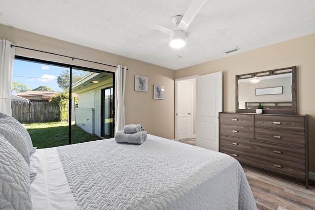 1251 SW Sudder Ave, Port Saint Lucie, FL 34953 - bedroom with access to exterior, a textured ceiling, light wood-type flooring, and a ceiling fan