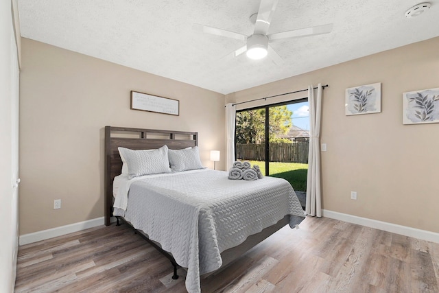 1251 SW Sudder Ave, Port Saint Lucie, FL 34953 - bedroom featuring access to outside, wood finished floors, a textured ceiling, and a ceiling fan